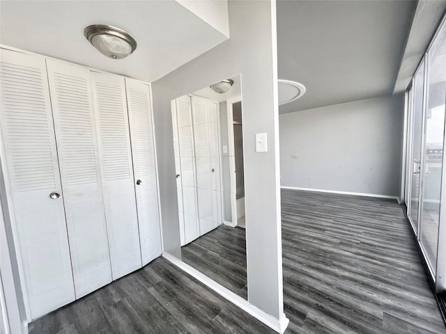 interior space with dark wood-type flooring and baseboards