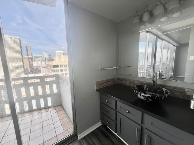 bathroom with a view of city, baseboards, and vanity