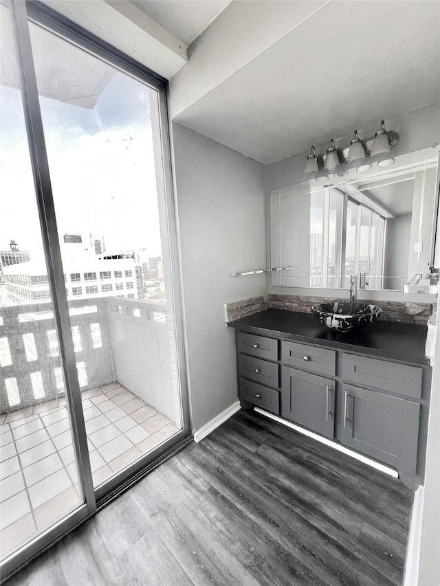 bathroom with vanity, a wealth of natural light, baseboards, and wood finished floors