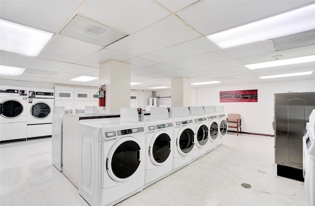 common laundry area featuring washing machine and clothes dryer, light floors, baseboards, and visible vents