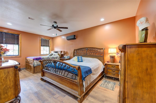 120 Rebecca St, Houston, TX 77022 - bedroom featuring wood finished floors, a wall mounted air conditioner, a ceiling fan, recessed lighting, and baseboards