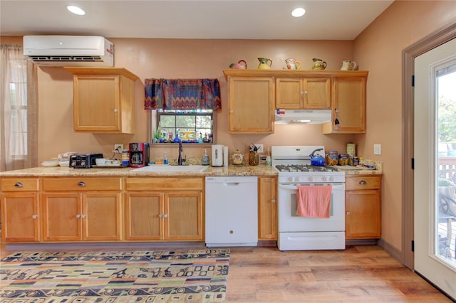 120 Rebecca St, Houston, TX 77022 - kitchen featuring white appliances, under cabinet range hood, a sink, a wall mounted AC, and light wood-style flooring