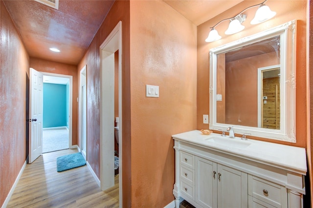 120 Rebecca St, Houston, TX 77022 - bathroom with wood finished floors, baseboards, vanity, and toilet