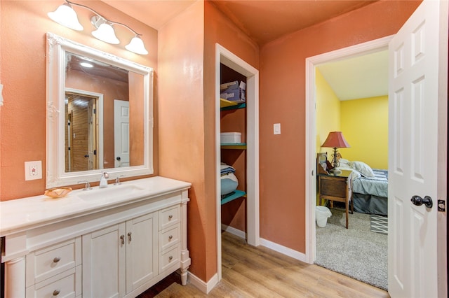 120 Rebecca St, Houston, TX 77022 - bathroom featuring wood finished floors, connected bathroom, vanity, and baseboards