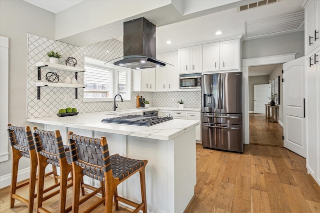 1411 Tulane St, Houston, TX 77008 - kitchen featuring stainless steel appliances, island exhaust hood, a peninsula, open shelves, and white cabinets