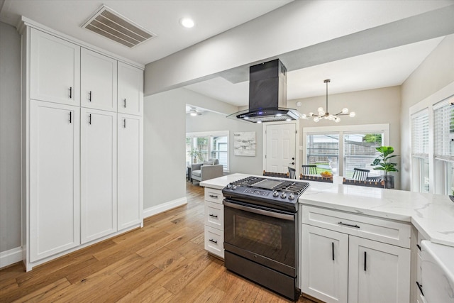 1411 Tulane St, Houston, TX 77008 - kitchen with gas stove, island range hood, a chandelier, light wood-style flooring, and white cabinets