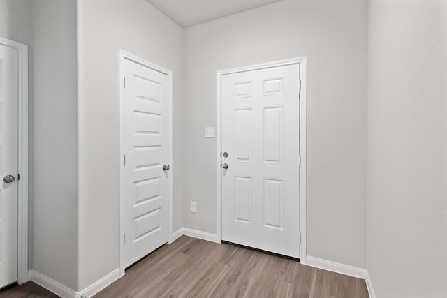 foyer entrance featuring baseboards and wood finished floors