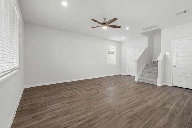 unfurnished living room with ceiling fan, visible vents, dark wood-type flooring, and stairs
