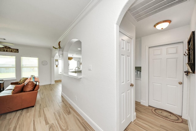 11202 Leah Elizabeth Dr, Needville, TX 77461 - foyer entrance featuring arched walkways, crown molding, light wood-type flooring, and baseboards