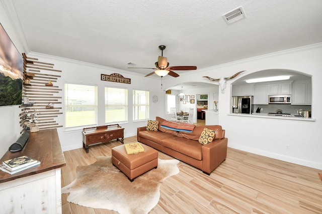 11202 Leah Elizabeth Dr, Needville, TX 77461 - living area with arched walkways, crown molding, a ceiling fan, wood finished floors, and baseboards