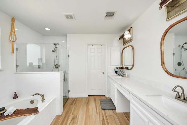 11202 Leah Elizabeth Dr, Needville, TX 77461 - full bath with a stall shower, a garden tub, double vanity, wood finished floors, and recessed lighting