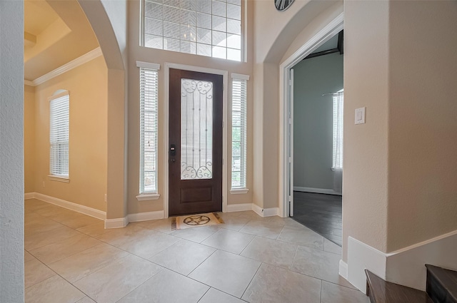 17019 Mahogany Trace Ln, Richmond, TX 77407 - tiled foyer entrance featuring crown molding, a textured wall, arched walkways, and baseboards