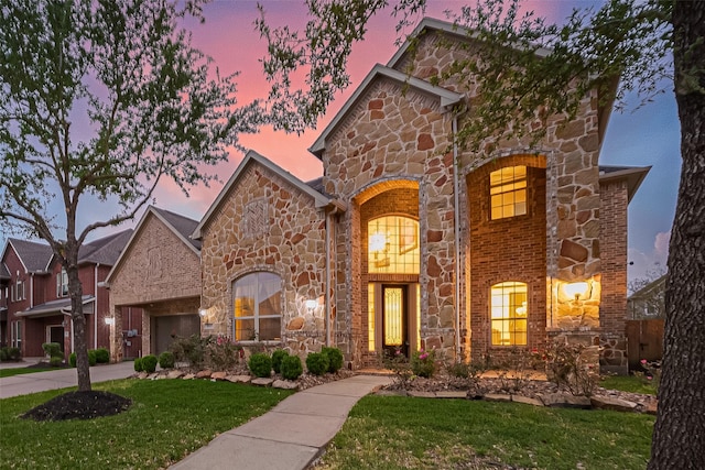 17019 Mahogany Trace Ln, Richmond, TX 77407 - view of front of house with stone siding, driveway, a garage, and a front lawn