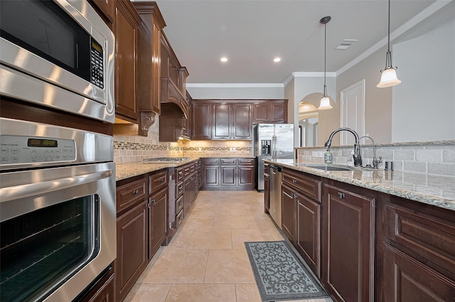 17019 Mahogany Trace Ln, Richmond, TX 77407 - kitchen featuring a sink, tasteful backsplash, ornamental molding, light stone countertops, and appliances with stainless steel finishes