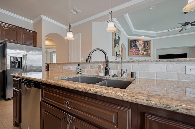 17019 Mahogany Trace Ln, Richmond, TX 77407 - kitchen featuring a sink, ornamental molding, visible vents, arched walkways, and appliances with stainless steel finishes