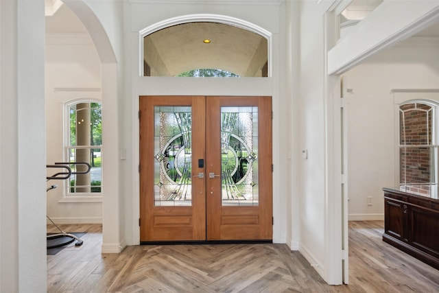 entryway with french doors, baseboards, and arched walkways