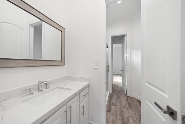 bathroom with baseboards, vanity, and wood finished floors