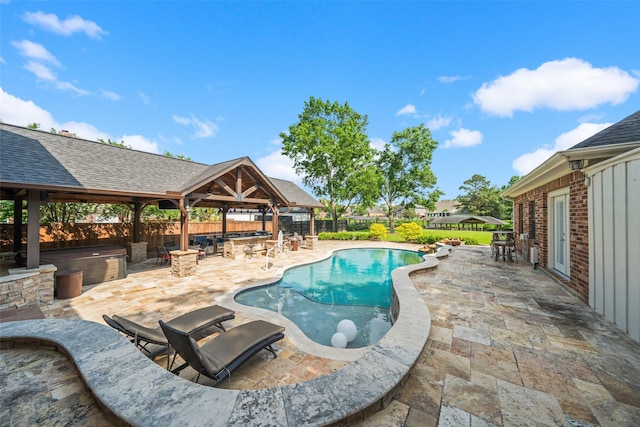 view of swimming pool with a hot tub, a gazebo, outdoor dry bar, a patio, and a fenced backyard