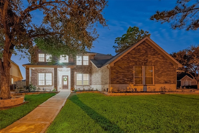view of front of property with stone siding, brick siding, and a front lawn