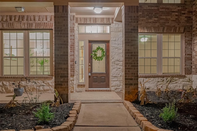 doorway to property with stone siding and brick siding