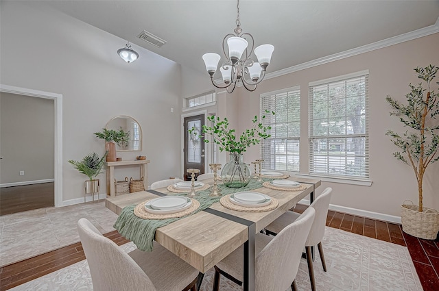 dining space with baseboards, an inviting chandelier, visible vents, and wood finished floors