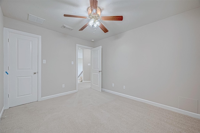 unfurnished bedroom with baseboards, light carpet, visible vents, and a ceiling fan