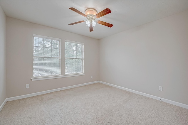 carpeted empty room with baseboards and ceiling fan