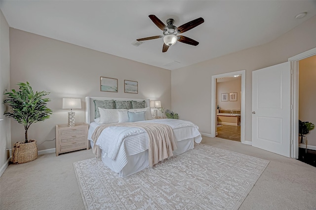 carpeted bedroom with ensuite bathroom, baseboards, a ceiling fan, and visible vents