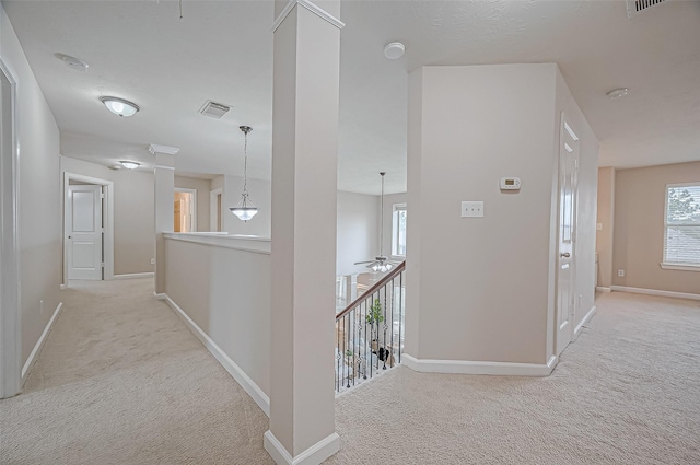 corridor featuring an upstairs landing, carpet flooring, baseboards, and visible vents
