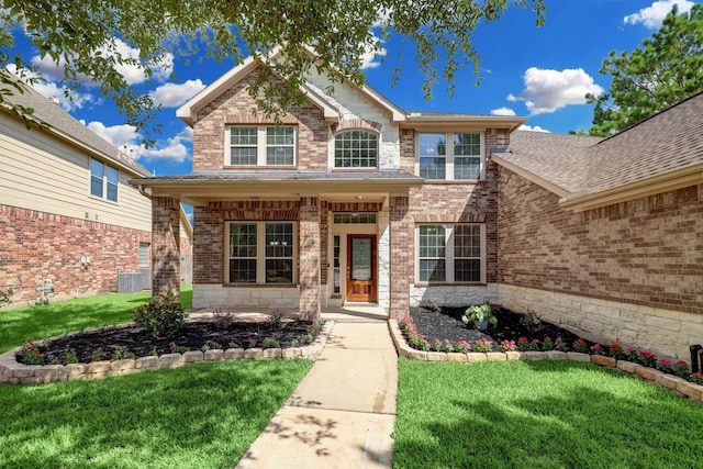 traditional-style home featuring covered porch, a front lawn, and brick siding