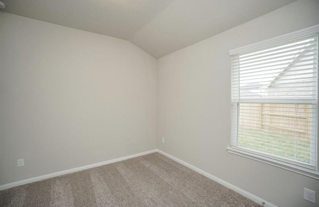 unfurnished room featuring vaulted ceiling, carpet, and baseboards