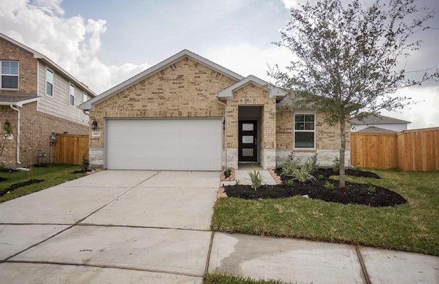 view of front of home with driveway, brick siding, an attached garage, and fence