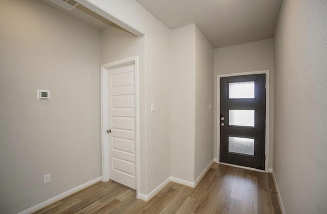 foyer featuring baseboards, visible vents, and light wood-style floors