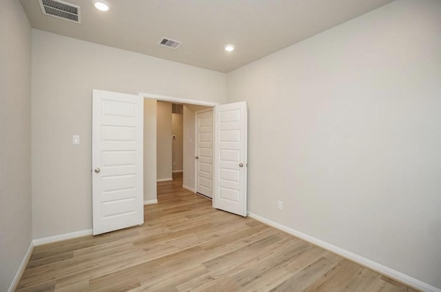 unfurnished bedroom featuring baseboards, visible vents, and light wood-style floors