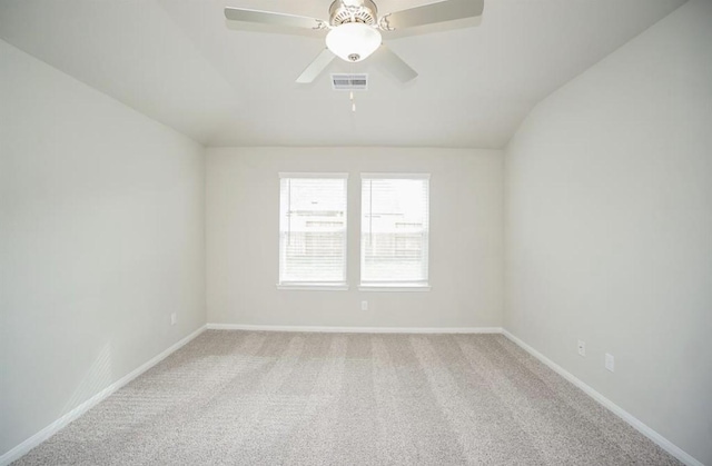 empty room with ceiling fan, lofted ceiling, carpet flooring, and visible vents