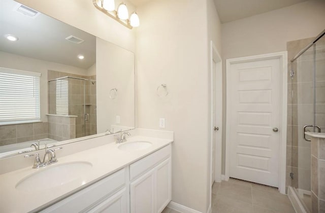 bathroom featuring a sink, tile patterned flooring, double vanity, and a shower stall
