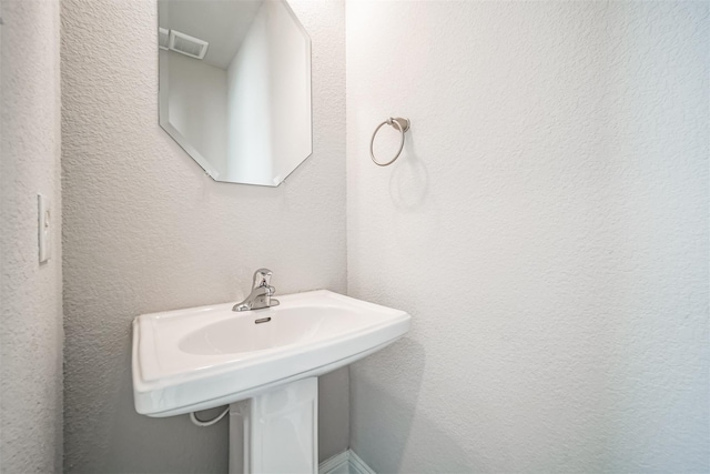 bathroom featuring visible vents and a sink