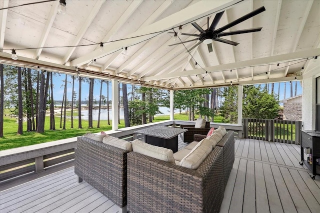 deck featuring a gazebo, a yard, an outdoor living space, a ceiling fan, and a water view