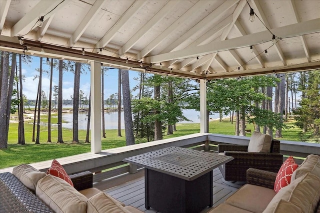 sunroom / solarium featuring a water view, beamed ceiling, and plenty of natural light