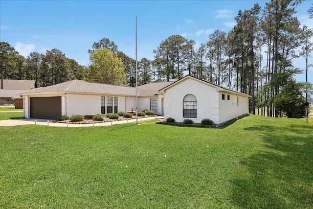 ranch-style house featuring concrete driveway, an attached garage, and a front yard