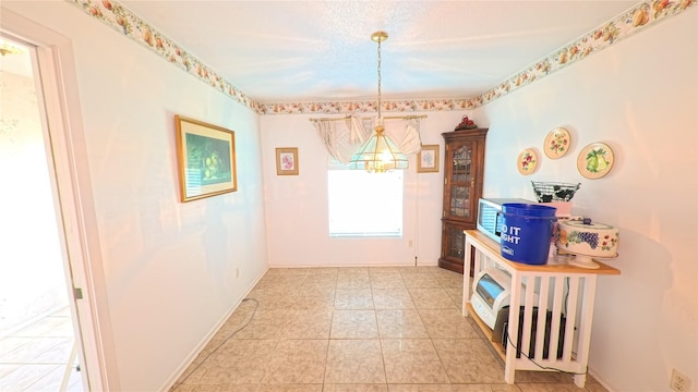 dining area with light tile patterned floors and a chandelier