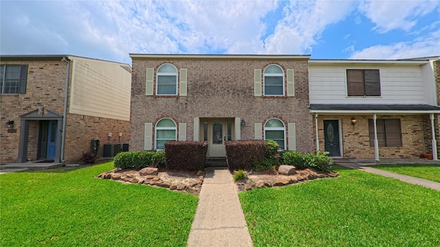 multi unit property featuring a front lawn and brick siding