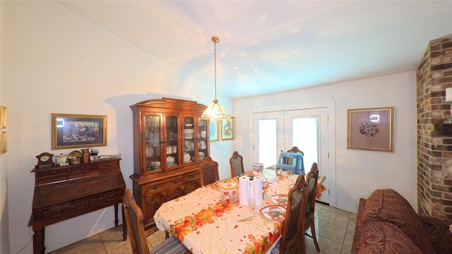 dining room featuring light tile patterned floors, vaulted ceiling, and french doors