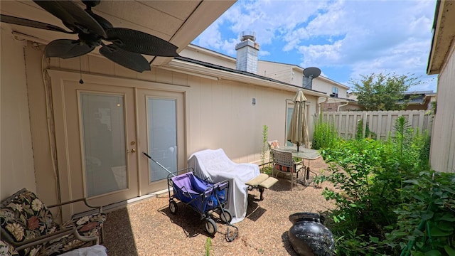 view of patio featuring french doors, fence, and a ceiling fan