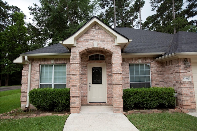 13847 Ventura Rd, Willis, TX 77318 - entrance to property with a lawn, brick siding, and roof with shingles