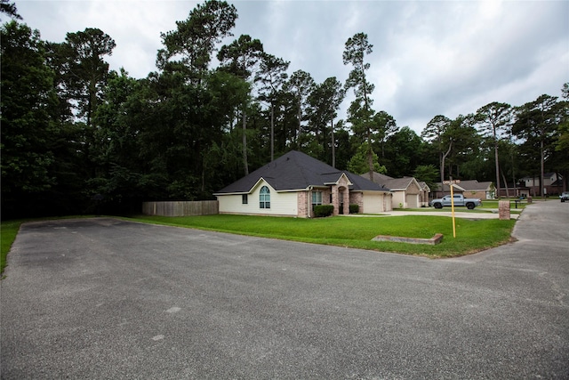 13847 Ventura Rd, Willis, TX 77318 - view of front of home featuring driveway, a front lawn, and fence