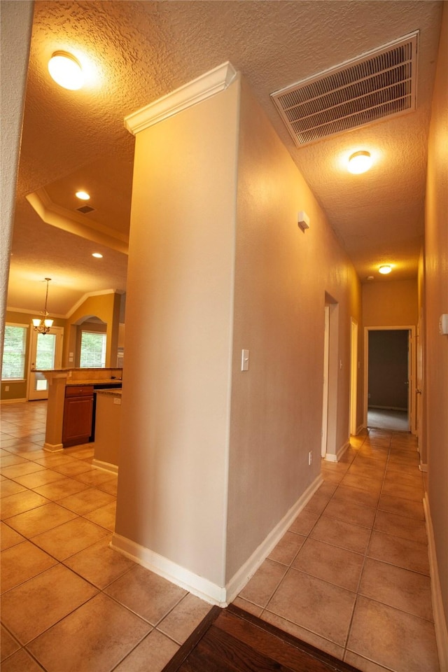 13847 Ventura Rd, Willis, TX 77318 - corridor featuring a textured ceiling, baseboards, light tile patterned floors, and visible vents