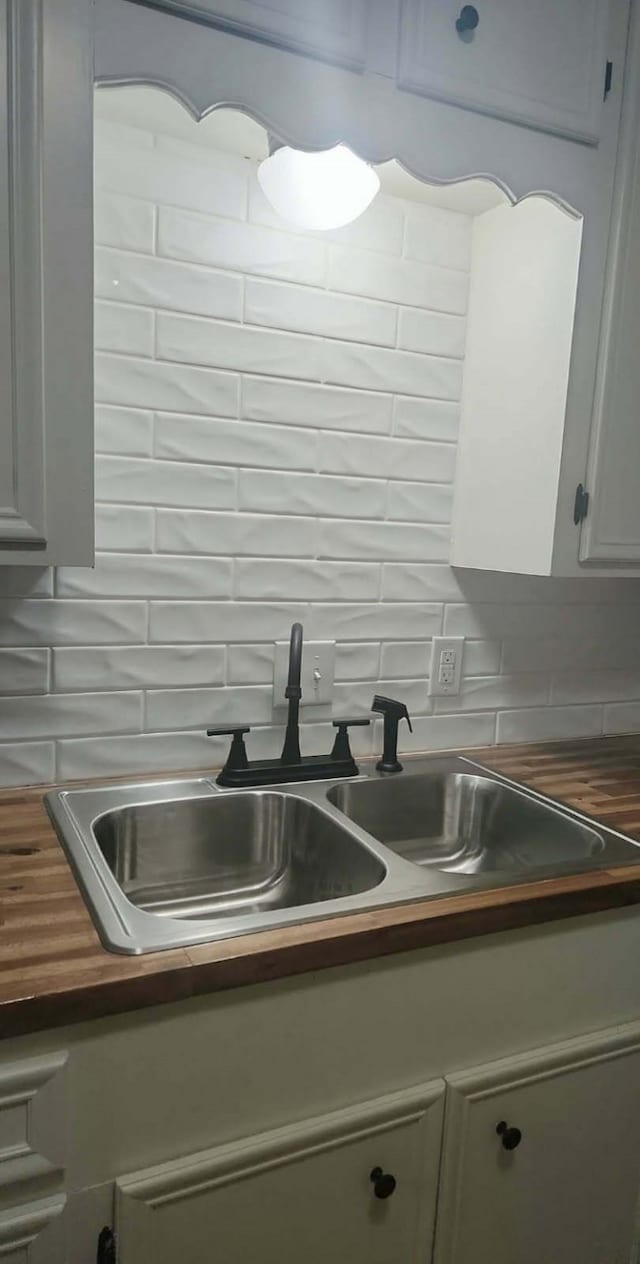 4308 Red Oak Dr, Nacogdoches, TX 75965 - kitchen with backsplash, butcher block countertops, white cabinetry, and a sink