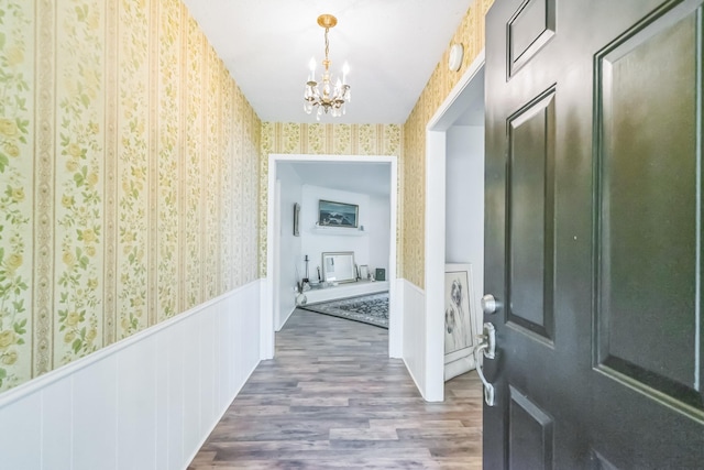 4308 Red Oak Dr, Nacogdoches, TX 75965 - hallway featuring a notable chandelier, wainscoting, wallpapered walls, and wood finished floors