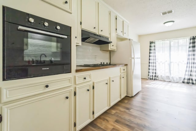 4308 Red Oak Dr, Nacogdoches, TX 75965 - kitchen featuring stovetop, freestanding refrigerator, oven, visible vents, and under cabinet range hood